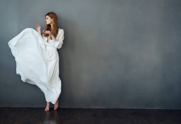 fröhliche Frau im weißen Kleid Tanz Unterhaltung eleganten Stil dunklen Hintergrund - Foto, Bild