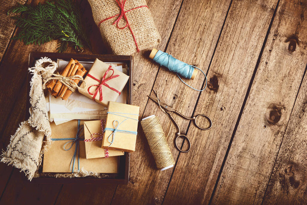 Boże Narodzenie, noworoczna kompozycja z pudełkami na drewnianym stole. Przygotowania do ferii zimowych - Zdjęcie, obraz