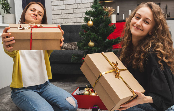 Zwei erwachsene Frauen freuen sich über ihre Weihnachtsgeschenke. - Foto, Bild