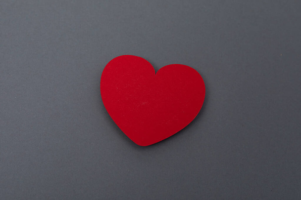 Un corazón rojo aislado sobre fondo gris - concepto de San Valentín - Foto, imagen