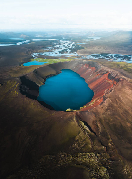 A vertical shot of a beautiful crater lake and a river under a misty sky in Iceland - Foto, Bild