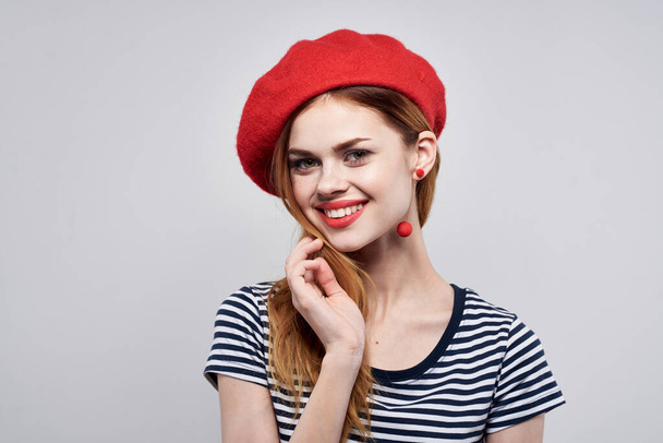 vrolijk vrouw poseren mode aantrekkelijk kijken rood oorbellen sieraden licht achtergrond - Foto, afbeelding