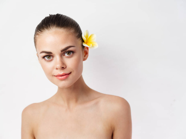可愛い女性明るいメイク裸の肩黄色の花 - 写真・画像