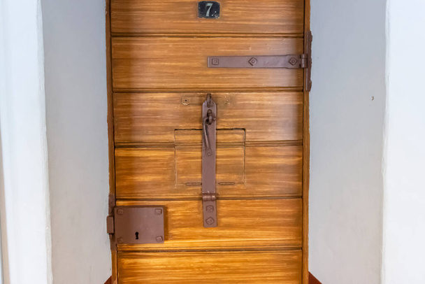 Uma porta de madeira para uma cela solitária na antiga prisão russa. - Foto, Imagem