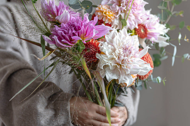 Heller festlicher Strauß mit Chrysathemenblüten in weiblichen Händen, helles Blumengesteck. - Foto, Bild