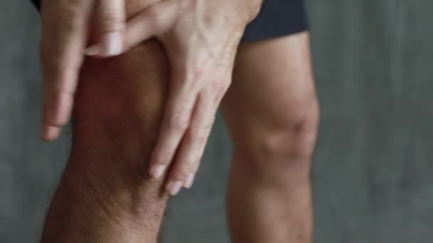 Закрыть человека с болью в колене, рука массирует его больное колено. Здравоохранение и медицинская концепция. - Кадры, видео
