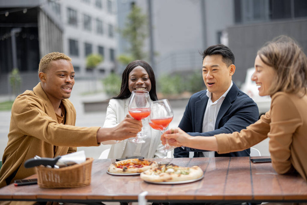 Группа деловых людей празднует в кафе на открытом воздухе - Фото, изображение