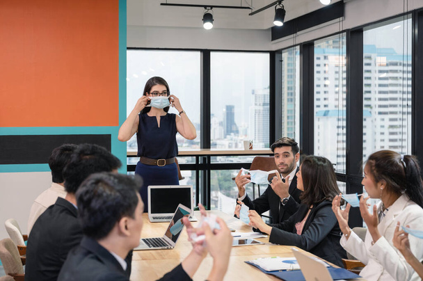Executivo caucasiano propõe política da empresa sobre o uso de máscara facial na empresa durante a reunião. Novo escritório normal. Enquanto pandemia de Coronavirus - Foto, Imagem