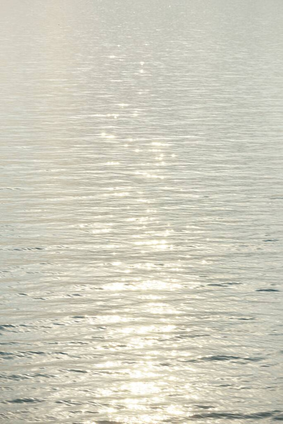 orilla del mar Báltico (dunas de arena) al atardecer. Cielo azul claro y luz dorada del sol, reflejos en un agua tranquila. Patrón natural abstracto, textura, fondo, paisaje marino, imagen conceptual, recursos gráficos - Foto, imagen