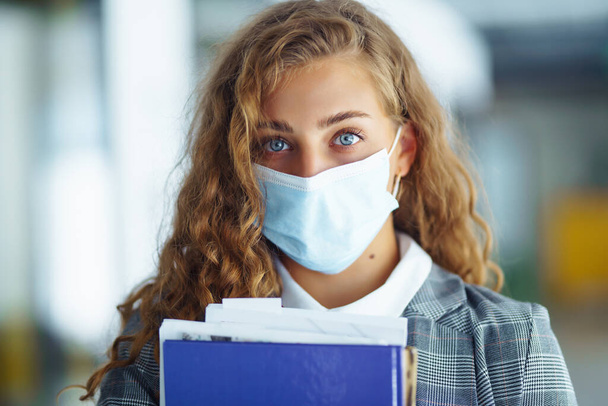 Portrait of young business woman in protective face mask at office. Female Entrepreneur. People, business, freelance, work concept. COVID - 19. - Foto, imagen