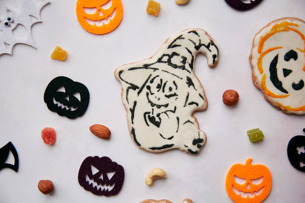 Homemade pumpkin and ghost cookies and Halloween felted decorations with nuts and candied fruits. Trick or treat, autumn holidays concept. High quality photo. - Photo, Image