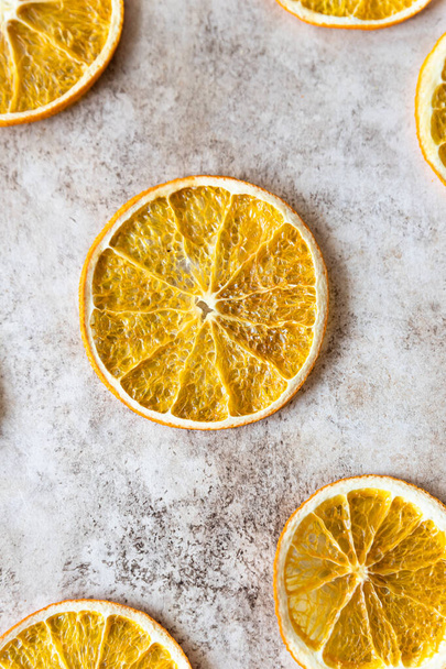 Pattern with slices of dried orange on light concrete background. Food background. Top view. Flat lay. - Фото, изображение