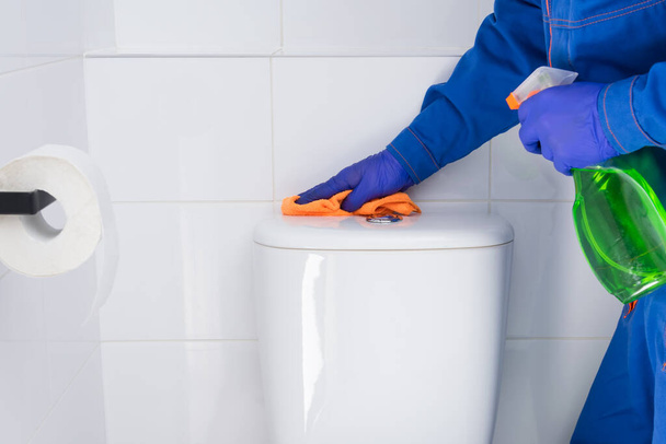 an employee of a cleaning company wipes the toilet bowl using special detergents - Foto, afbeelding