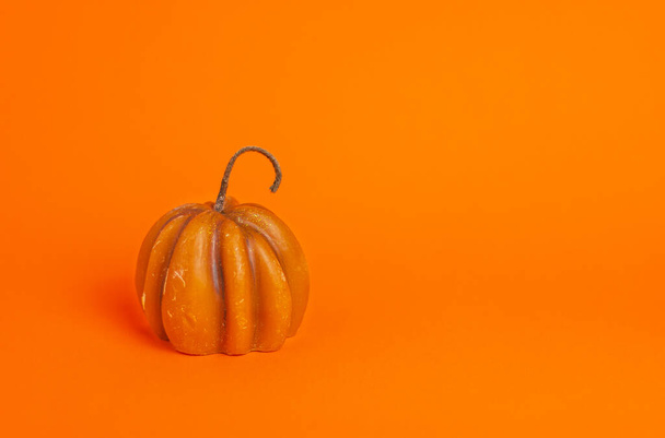 miniatűr sütőtök gyertya narancssárga alapon fénymásoló hellyel. halloween, hálaadás, szüreti fesztivál koncepció - Fotó, kép