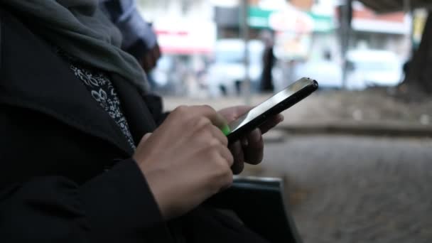 Musliminainen käyttää älypuhelinta
  - Materiaali, video
