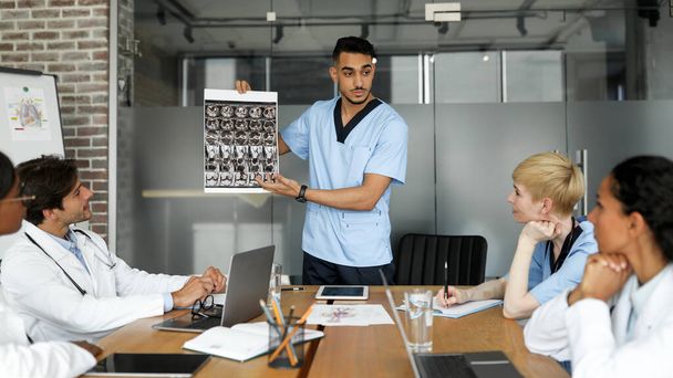 Arabo uomo medico mostrando i suoi colleghi MRI scansione - Foto, immagini