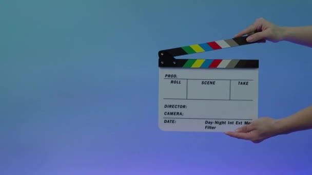 Clapperboard hitting. Movie film slate. close up hand clapping empty film slate on blue or green screen color background. in and out film slate cutting for video production. film or Movie shooting. - Footage, Video