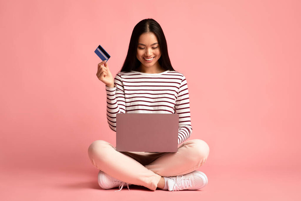 Shopping online. Bella giovane donna asiatica che utilizza computer portatile e carta di credito - Foto, immagini
