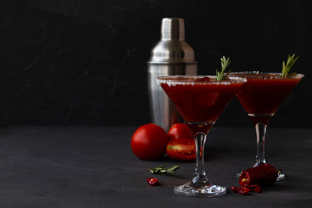 Bloody Mary cocktail. Alcoholic drink with vodka and tomato juice in a glass isolated on a black background. vampiro cocktail with pepper on a busy bar top. copy space. - Photo, Image
