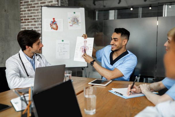 Positive middle-eastern man chief doctor making presentation for colleagues - Photo, Image