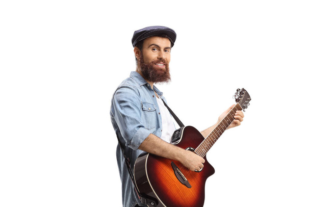 Bearded guy playing an acoustic guitar isolated on white background - Fotografie, Obrázek