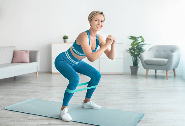 Smiling Woman In Sportswear Exercising With Resistance Band - Photo, Image