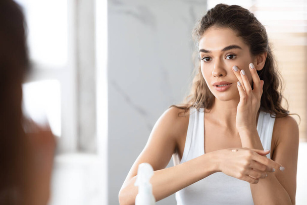 Young Woman Making Makeup Applying Foundation Standing In Bathroom - Photo, Image