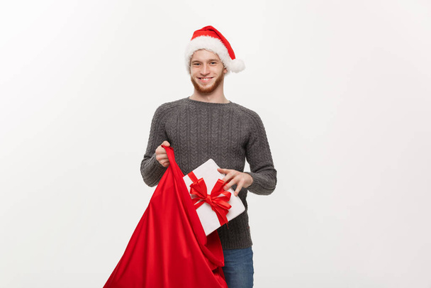 Christmas Concept - Young happy beard man excite with big present in santa bag. - Photo, Image