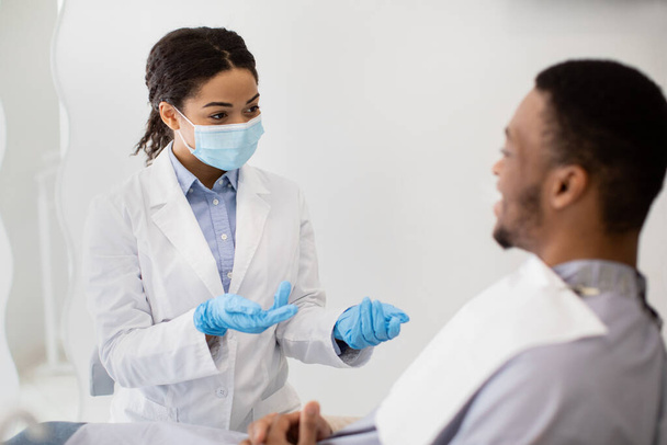 Controlli dentali. nero stomatologo signora consulenza maschio paziente in clinica - Foto, immagini