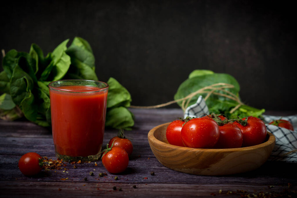 cherry tomatoes and tomato juice on a black background. Tomato cocktail with tomatoes - Photo, Image