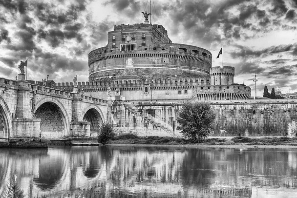 View of Castel Sant'Angelo fortress and bridge with beautiful reflections on the Tiber River in Rome, Italy. Aka Mausoleum of Hadrian, the building was used in the middle ages as a castle by the popes - Photo, Image