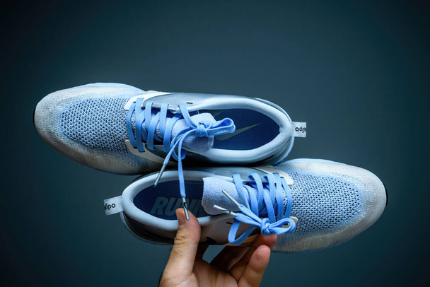 Pov male hand holding new pair of luxury running shoes Nike Zoom react - 写真・画像