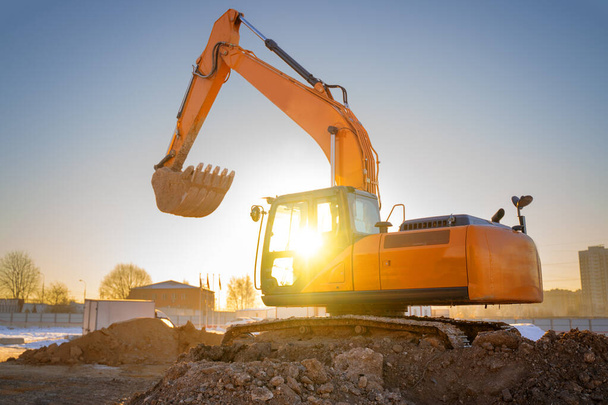 Orange color excavator on the construction site at sunset. Industrial image - Foto, Imagen