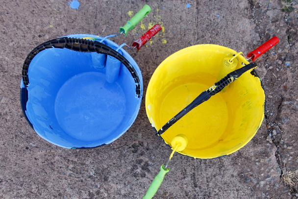 Mavi ve sarı boyalı kova ve boya fırçaları - Fotoğraf, Görsel