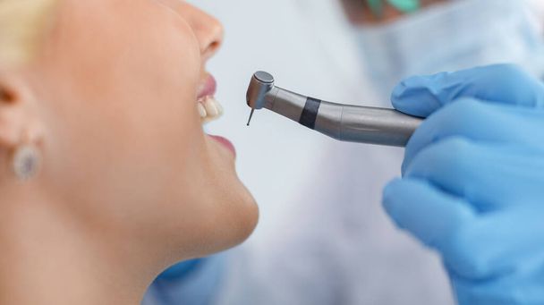 Cropped of young smiling woman and dentist hand with drill - Foto, afbeelding