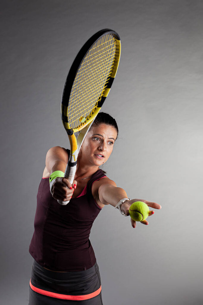 Professional female tennis player. Girl swinging racket. - Фото, изображение