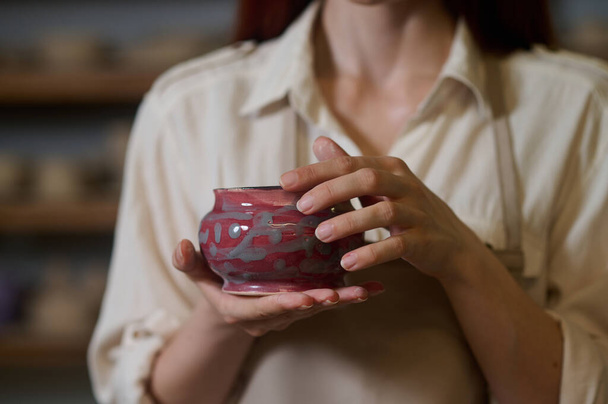 Female potter holding newlymade pots in hands - Fotografie, Obrázek
