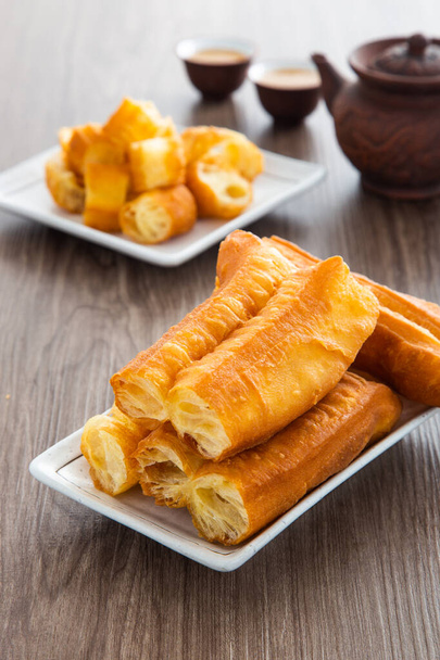 Youtiao (pain chinois frit). Longue bande de pâte frite brun doré. - Photo, image