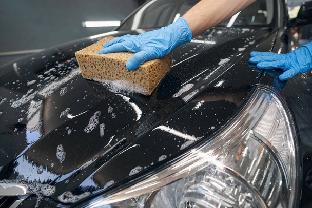 Detallador de coche lavado vehículo negro con esponja - Foto, Imagen