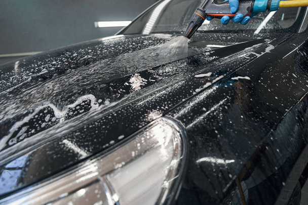 Handmatig wassen van auto 's met schuim op tankstation - Foto, afbeelding