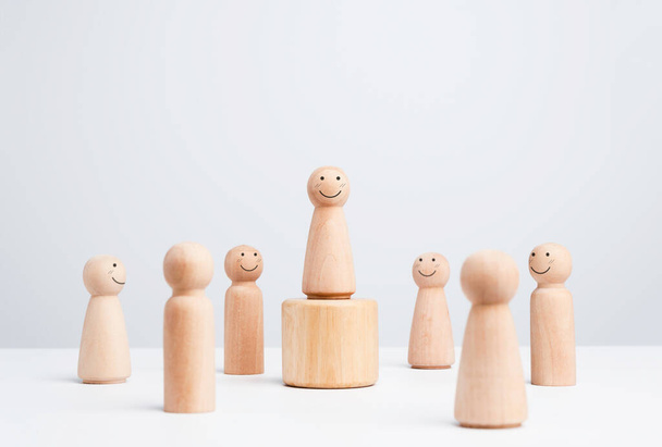 Leader woman, influencer, wooden figure, Smiling female standing on the box surrounding with the happy people on white background, minimal style. Leadership, and empowerment, and the winner concept. - Photo, Image