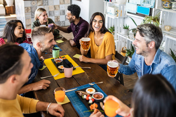 Группа счастливых многорасовых друзей завтракает в кафе-баре - Фото, изображение