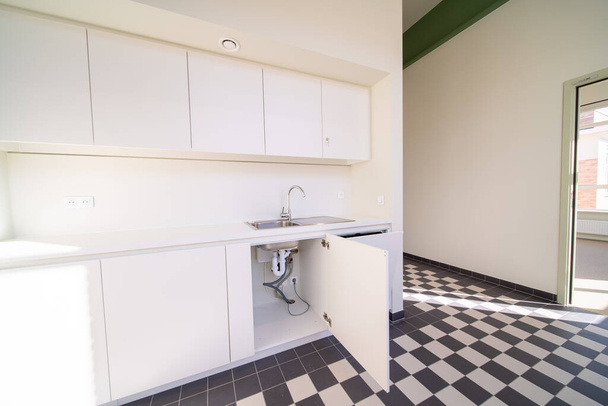 Debajo de un lavabo en una cocina moderna hay un calentador de agua caliente - Foto, Imagen