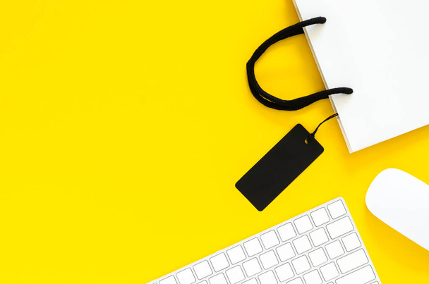 Draadloos toetsenbord en muis met boodschappentas voor online winkelen met gele achtergrond. Cyber Monday en Black Friday concept. - Foto, afbeelding