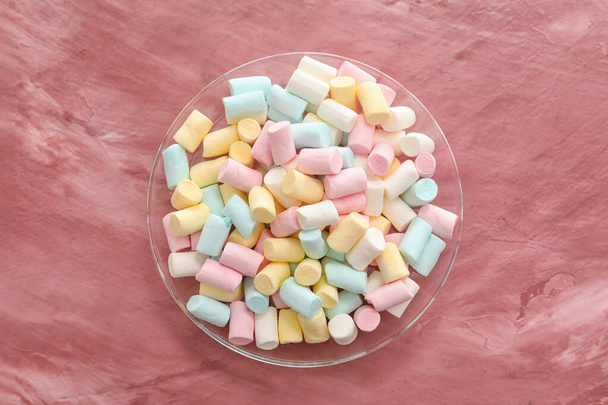 Bowl with tasty colorful marshmallows on color background - Fotó, kép