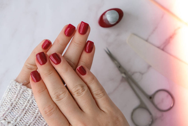 Stijlvolle rode vrouwelijke nagels. Modern Prachtige manicure. Herfst winter nagel ontwerp concept van schoonheid behandeling. Gel nagels. Huidverzorging. Welzijn. Trendy kleuren. - Foto, afbeelding