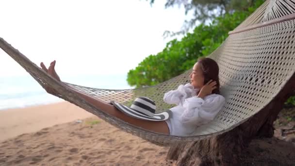 πλάνα από όμορφη Ασιάτισσα γυναίκα χαλαρώνοντας στην παραλία κατά τη διάρκεια των καλοκαιρινών διακοπών - Πλάνα, βίντεο