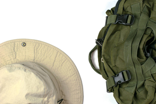 turistický batoh a klobouk na bílém povrchu s kopírovacím prostorem. Kvalitní fotografie - Fotografie, Obrázek