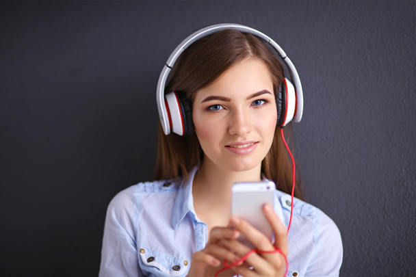 Smiling girl with headphones isolated on grey background - Photo, Image