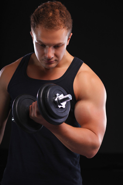 Fit muscular man exercising with dumbbell - Foto, immagini